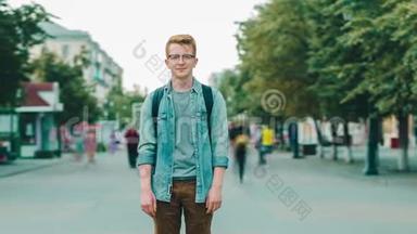 在城市的步行街上站着一个有魅力的红发男子
